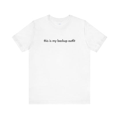 White t-shirt with black text 'this is my backup outfit' on a white background