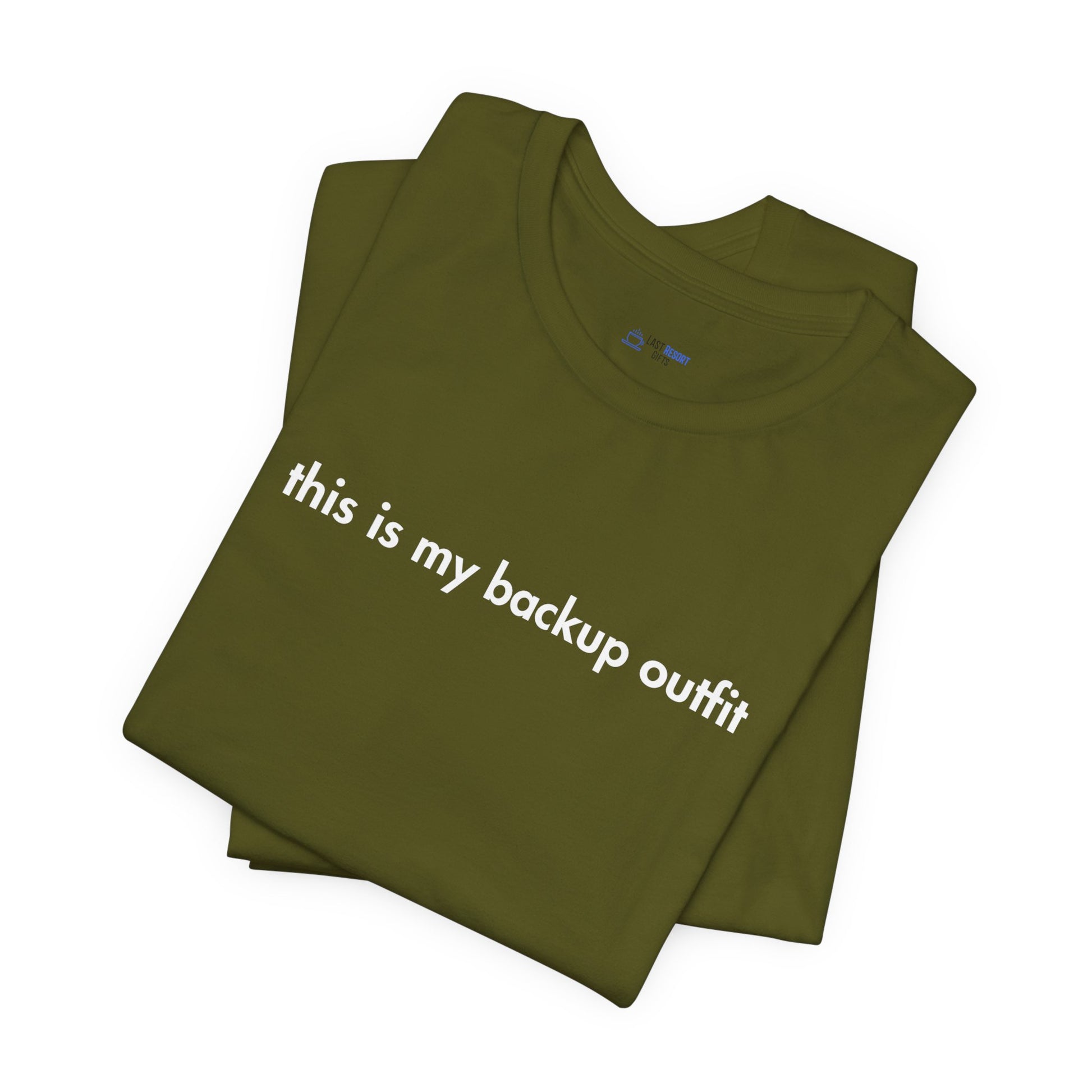 Folded green t-shirt with 'this is my backup outfit' text on a white background