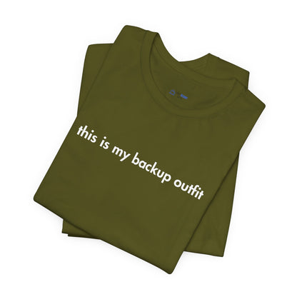 Folded green t-shirt with 'this is my backup outfit' text on a white background