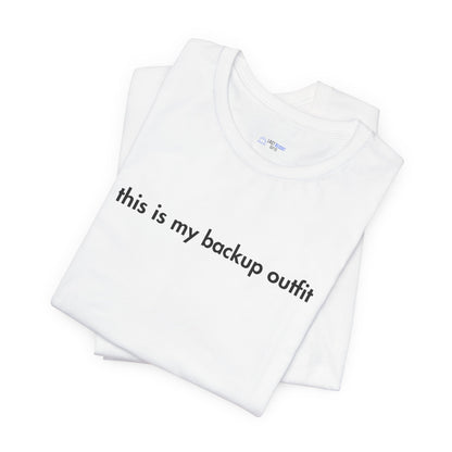 White t-shirt with text 'this is my backup outfit' on a white background