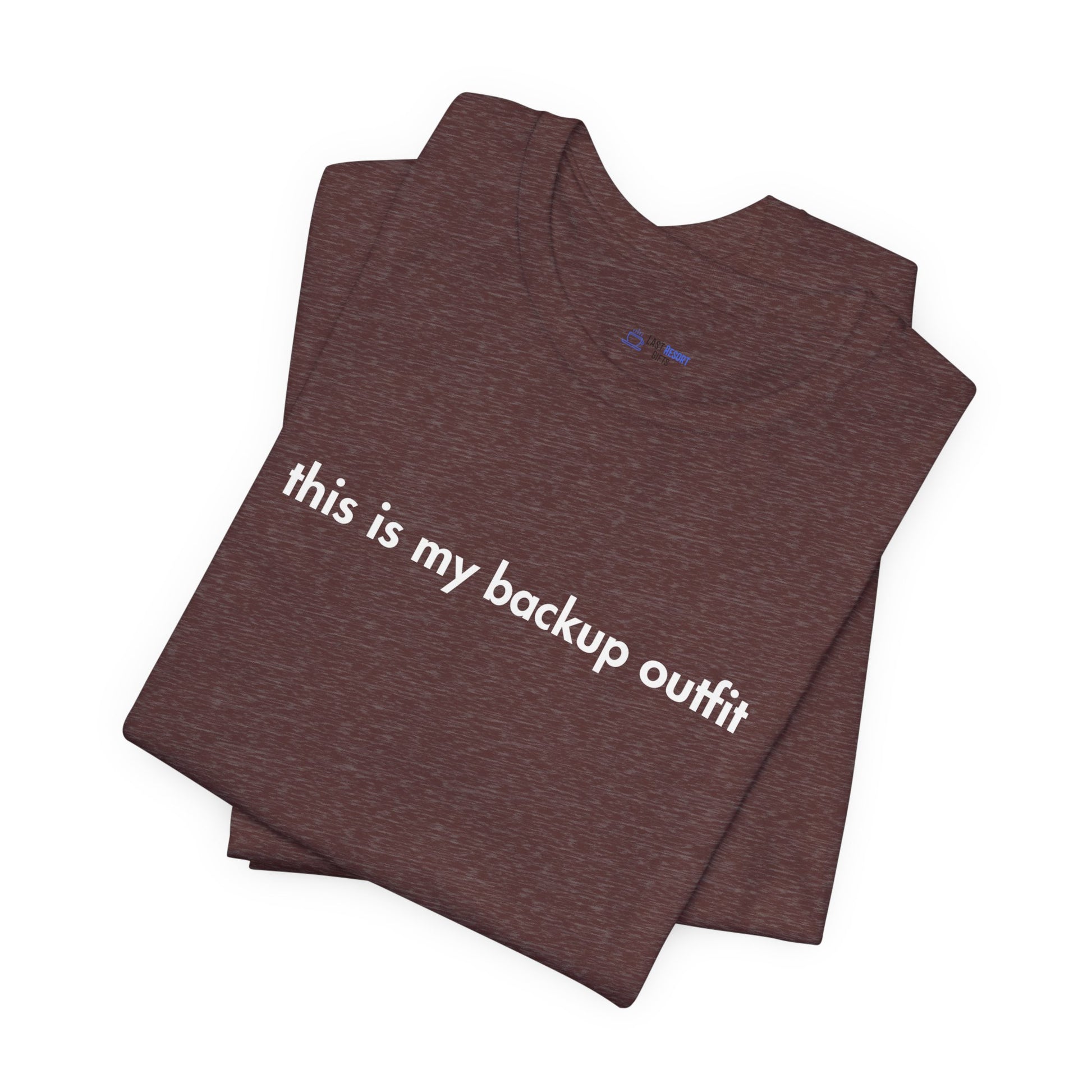 Folded brown t-shirt with 'this is my backup outfit' text on a white background