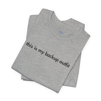 Folded gray t-shirt with text 'this is my backup outfit' on a white background